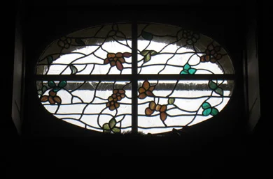 Vitraux fleuris en place, avec réseau de plomb et verres blancs texturés.