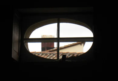 Oculus vitré donnant sur une cheminée dans une maison de campagne.
